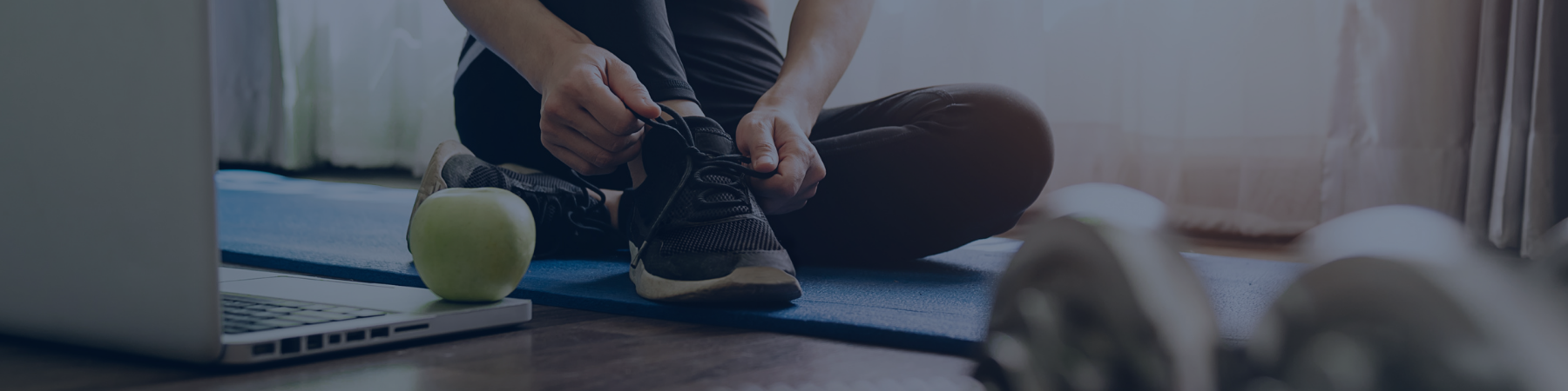 Woman in workout gear tying running shoe